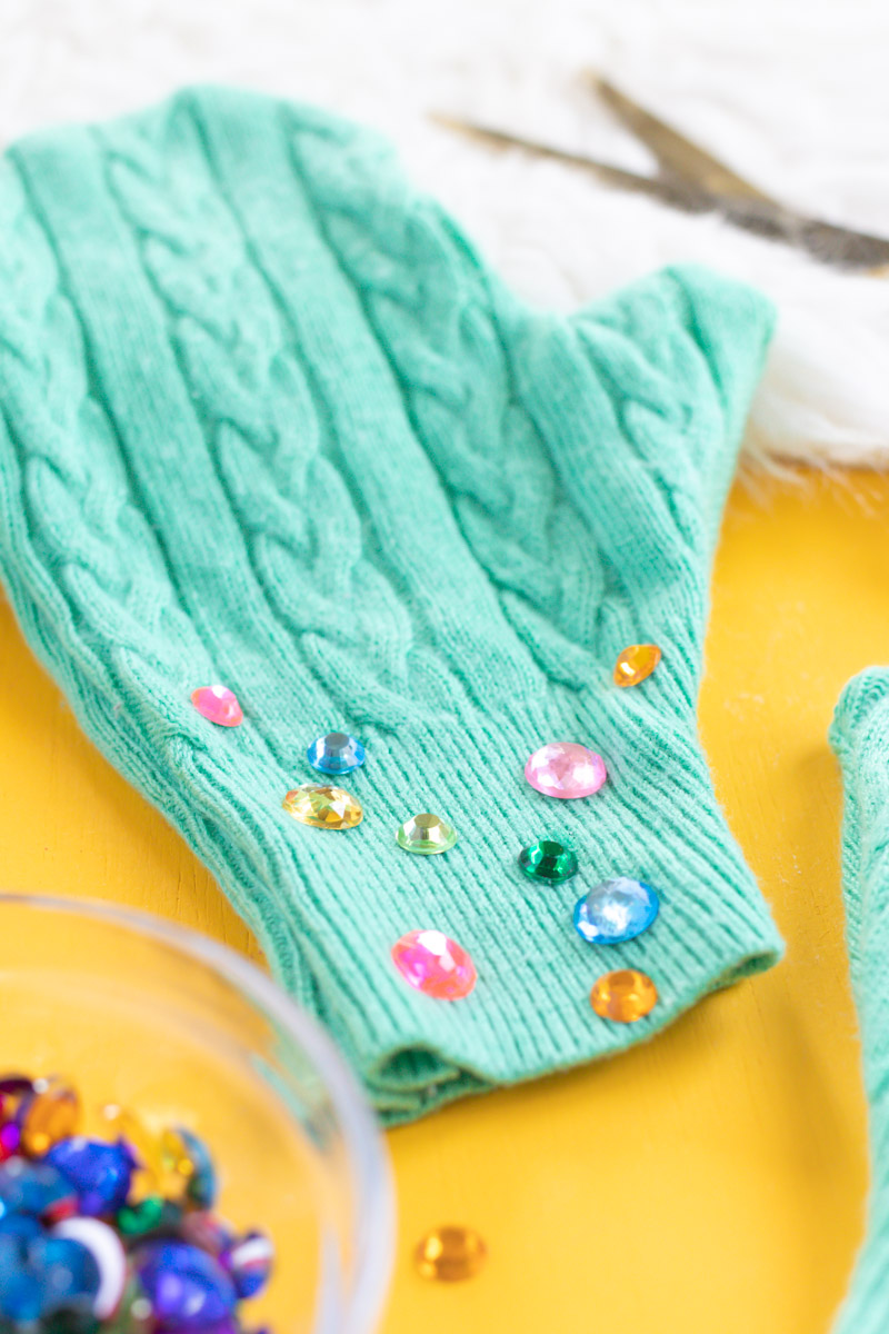 Upcycled Sweater DIY! Easy No-Sew Mittens // This easy upcycling DIY is perfect for giving new life to a thrifted sweater or old piece of clothing! Use a sweater and Aleene's Fabric Fusion to make no-sew mittens perfect for keeping warm this season. Add rhinestones for a little extra bling! #ad #nosew #diyfashion #diystyle #upcycledcrafts #bedazzled #nosewfashion #winterdiy #thrifteddiy