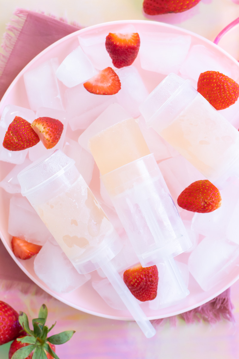 Easy Rosé Push Pops // Combine your favorite rosé wine, spirit and lemonade for refreshing homemade push pops or alcoholic popsicles! Enjoy push pops with less mess and a recipe with only 3 ingredients #popsicles #frozenrecipes #summerrecipes #froserecipes #pushpops #roserecipes #sangria #summercocktails #winecocktails #winepops