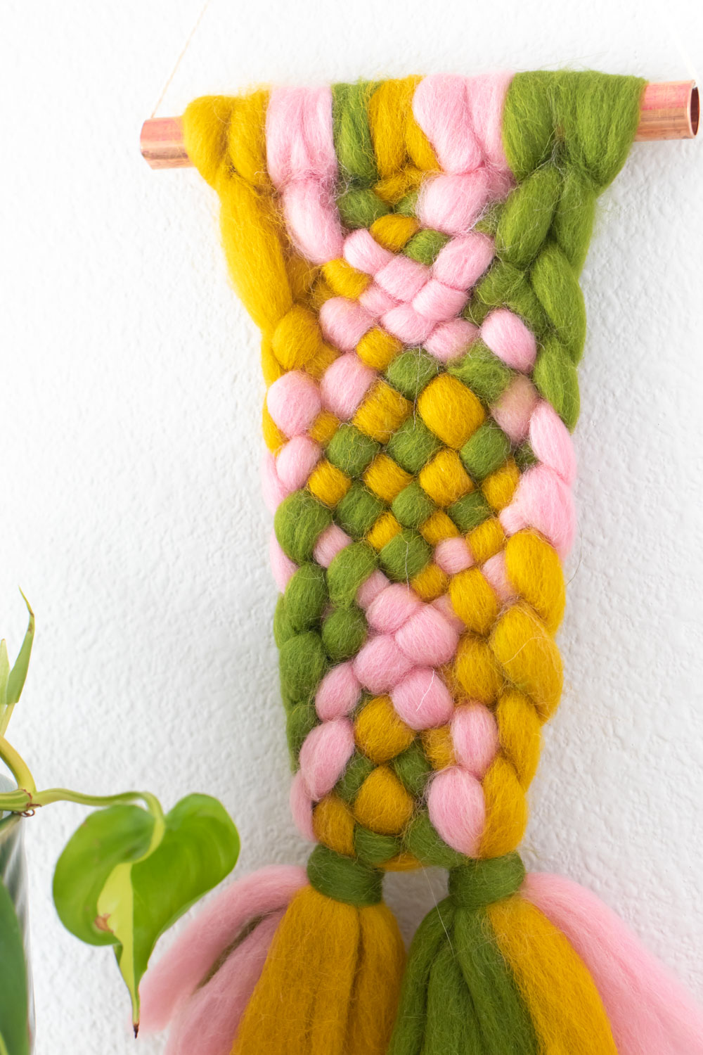 Closeup of colorful roving weaving on copper pipe