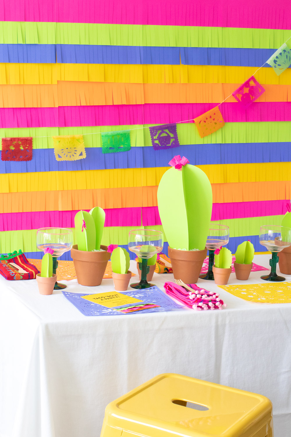 assortment of colorful paper fiesta decor, paper cacti, cacti glassware 