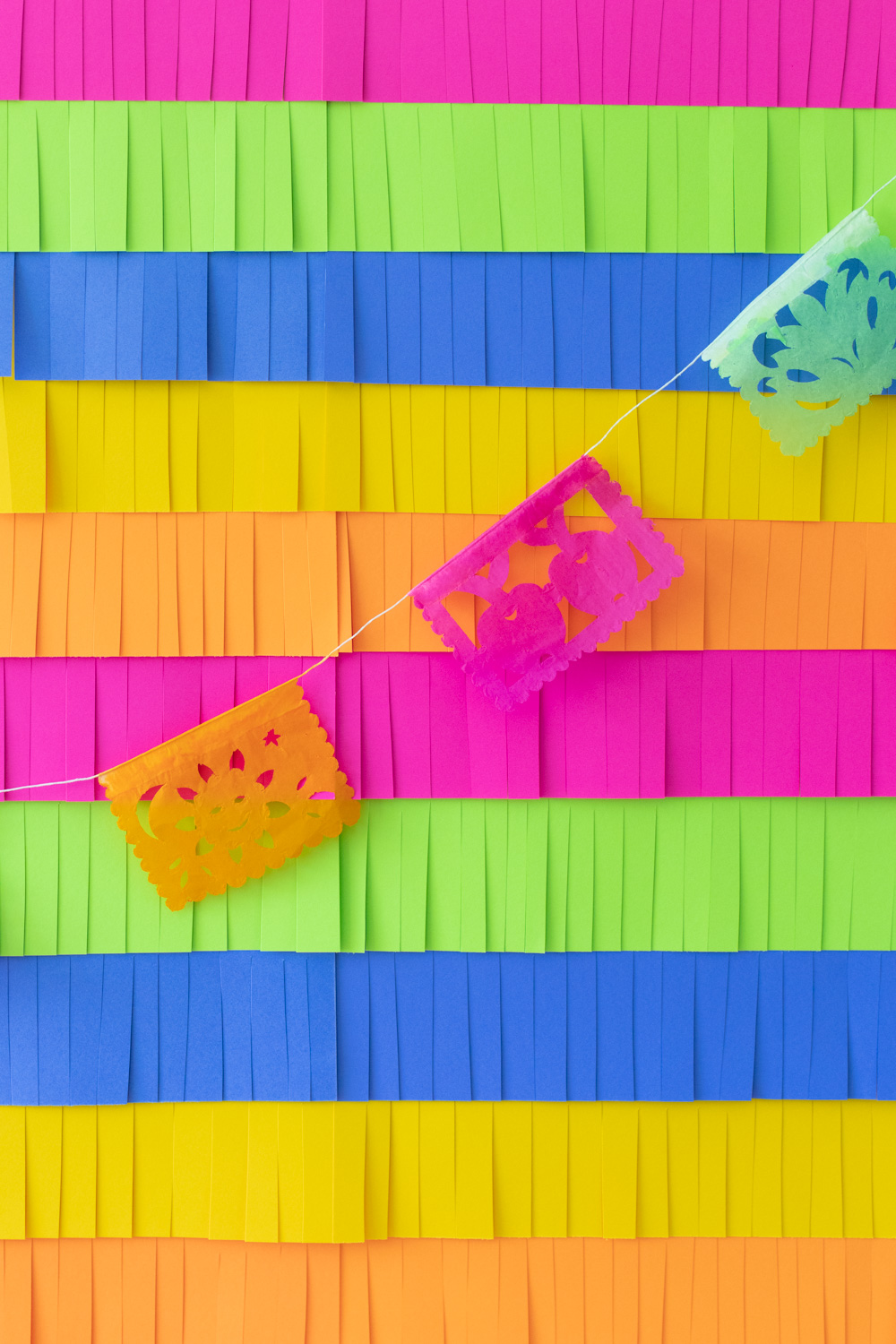 colorful paper fringe backdrop with papel picado flags