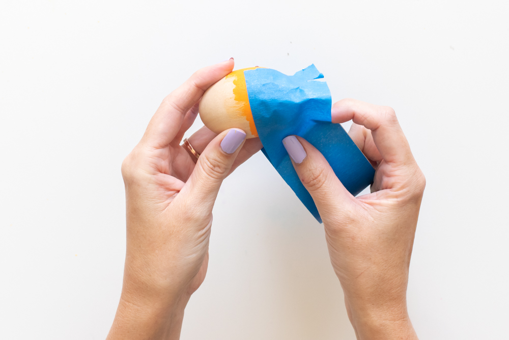applying tape to color blocked easter egg for marbling