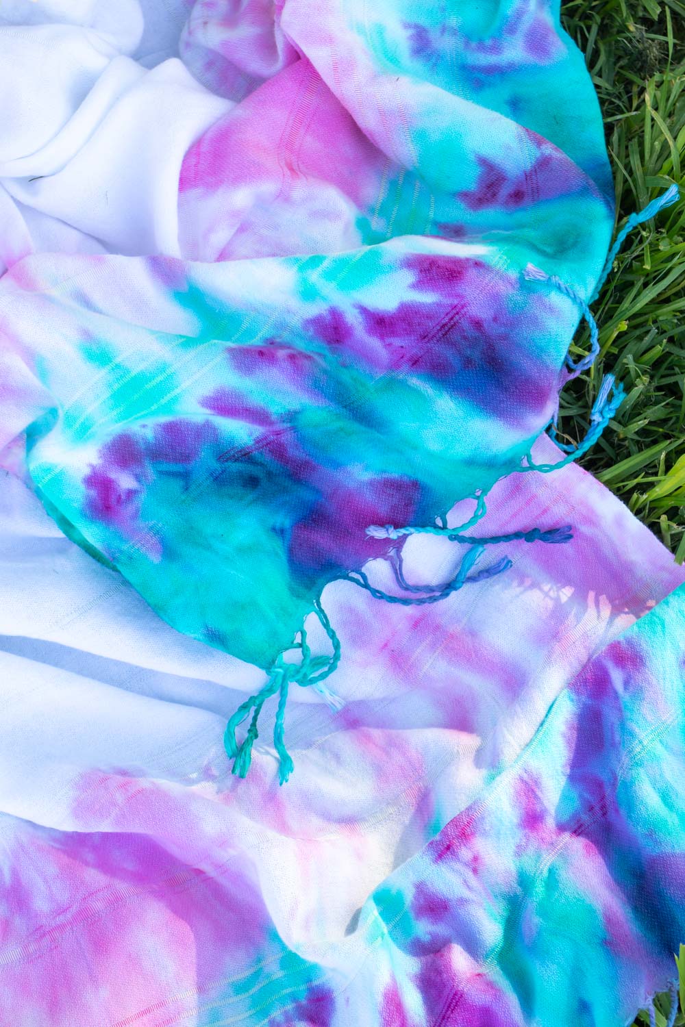 closeup of tie dye picnic blanket or towel with fringe