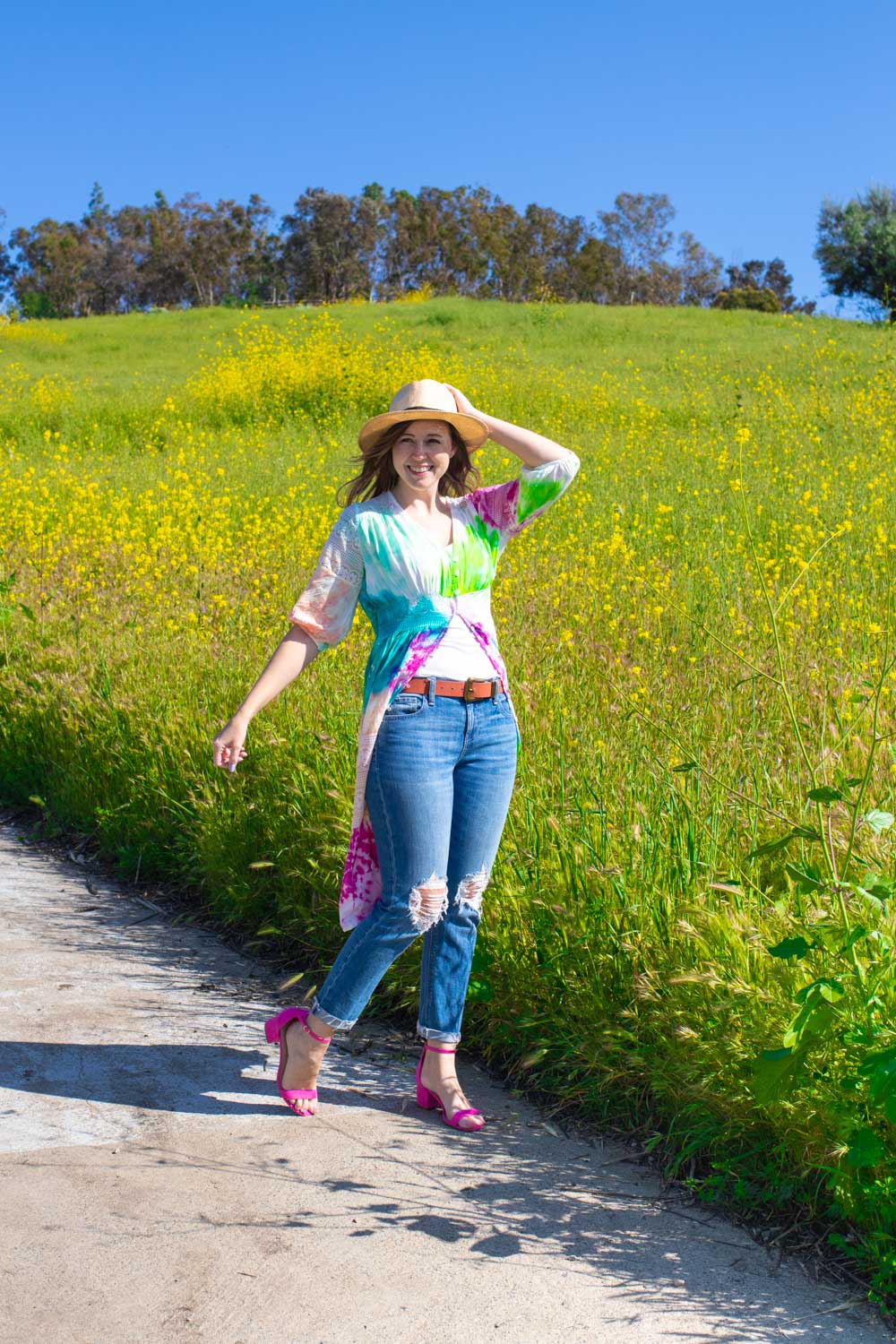 woman wearing tie dye kimono with jeans in front of wildflowers