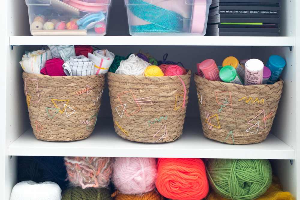 3 baskets filled with craft supplies on shelf in cabinet