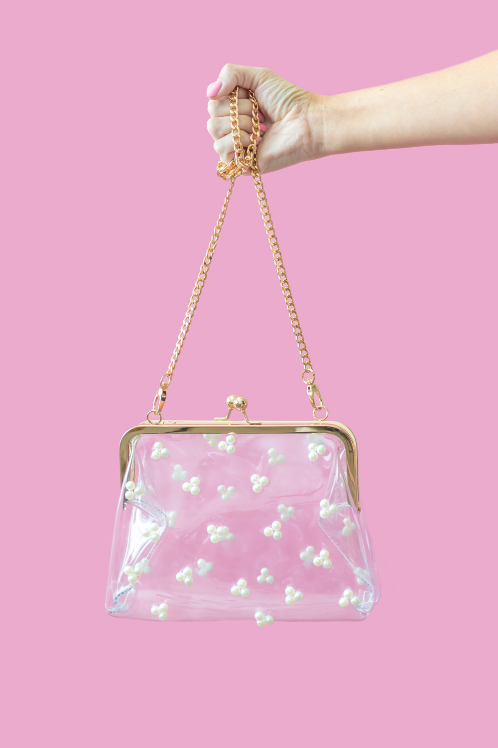 hand holding a clear pearl purse
