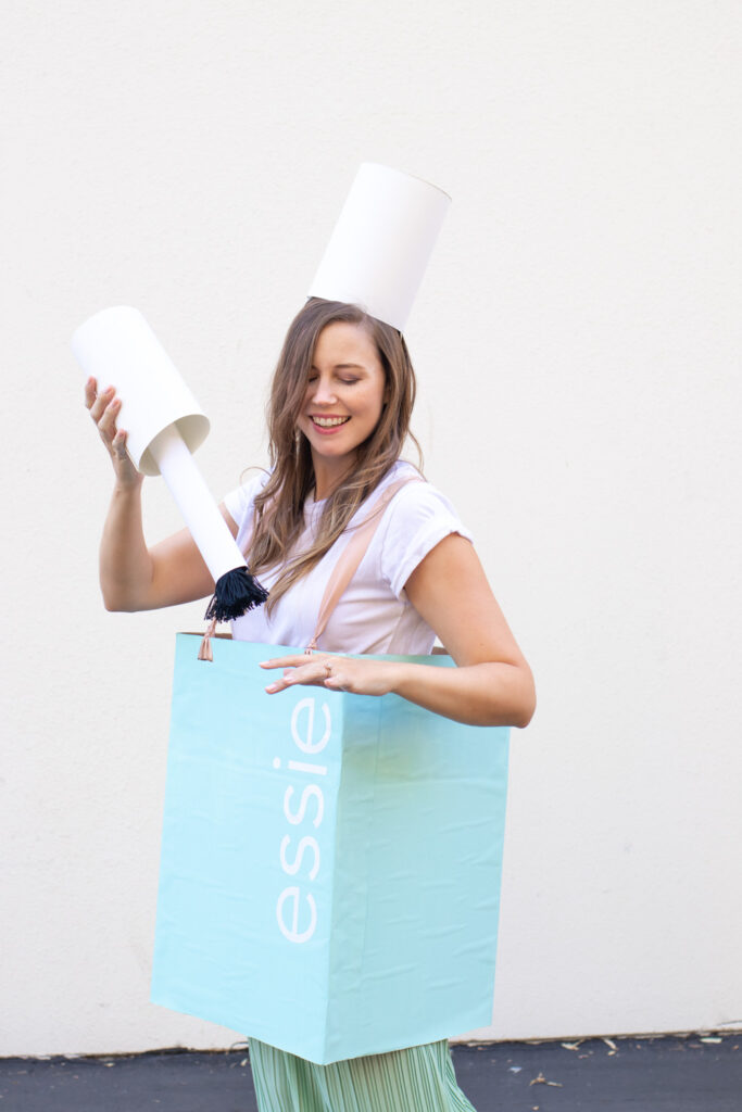 woman holding DIY nail polish brush to match costume
