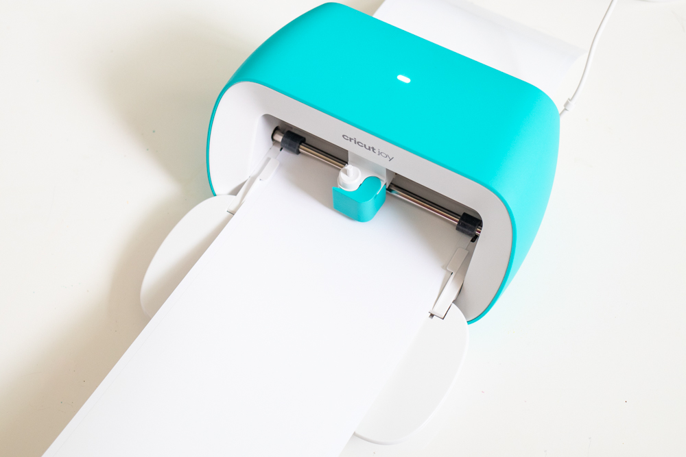 Cricut Joy machine cutting white vinyl