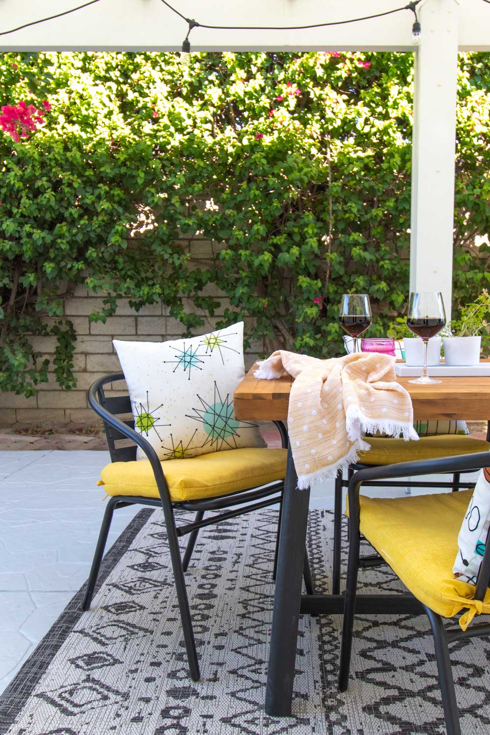 fall outdoor dining space with mid-century patterned pillows