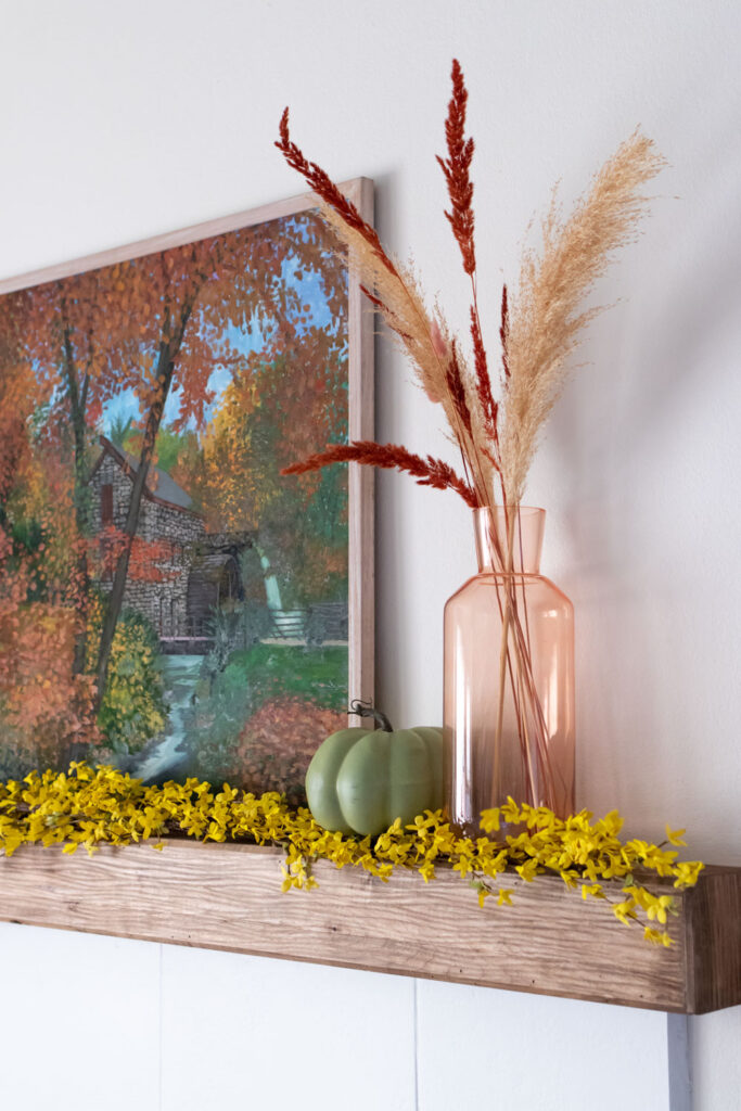 vase and decor on mantel above painted tile fireplace