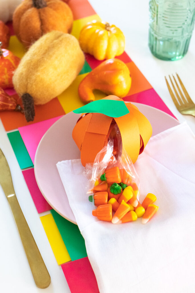 candy spilling out of pumpkin treat bag made of paper