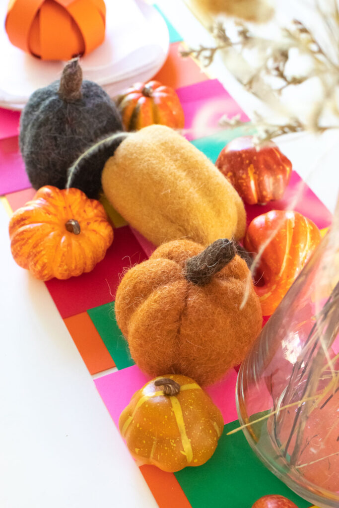 closeup of woven paper placemat and mini pumpkin decor
