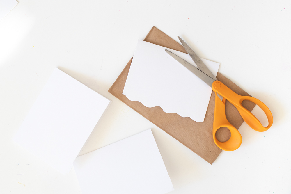 cutting white roofs for paper gingerbread house gift bags