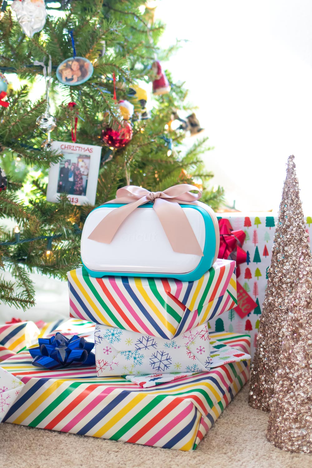 Cricut machine on top of wrapped gifts in front of tree