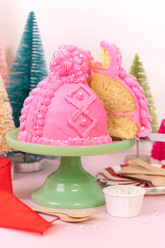 removing slice of winter hat cake with pom pom cupcake topper