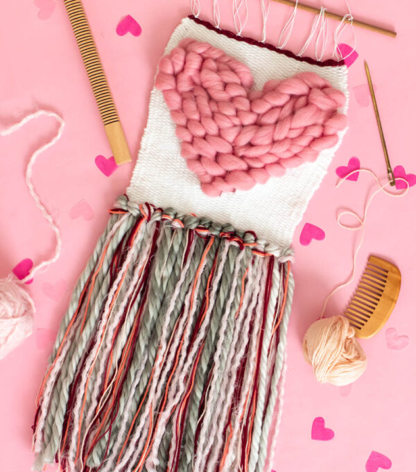 flatlay of heart weaving decor on pink background
