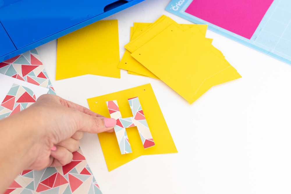 adding sticker letters to colorful bunting