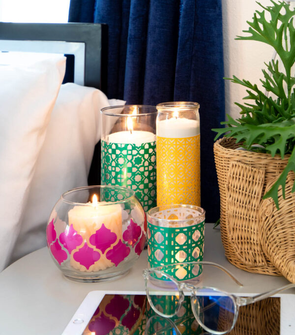 multiple boho candleholders on nightstand with tablet