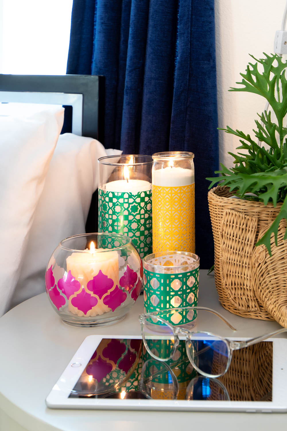 multiple boho candleholders on nightstand with tablet
