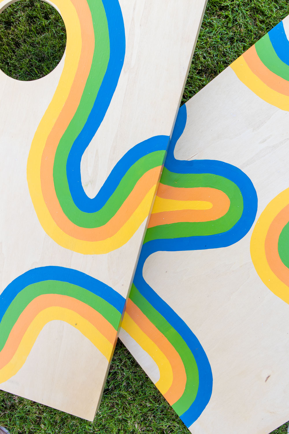 closeup of 70s-inspired painted cornhole makeover