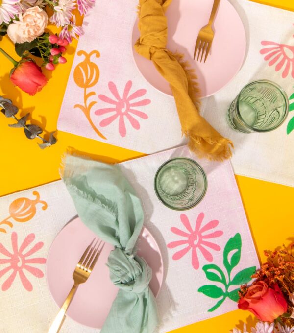 overhead view of two modern floral placemats with place settings and flowers
