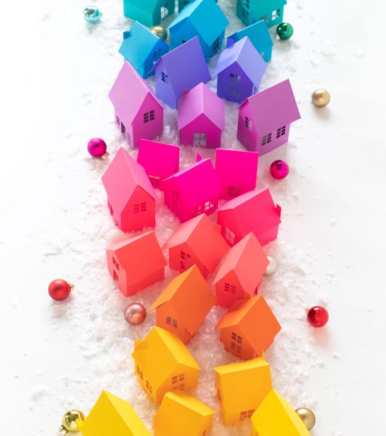 Rainbow Holiday Village with Paper + Free Templates | Club Crafted Rainbow Holiday Village with Paper + Free Templates for Cricut or Silhouette! // Decorate for Christmas with these paper houses made with vibrant Astrobrights cardstock! Turn the holiday village into a rainbow surrounded by fake snow, bottlebrush trees, and LED lights for a festive holiday display! #christmas #christmasdecor #diychristmas #holidayseason #holidaydecor #rainbow #papercrafts #freetemplate #freeprintable
